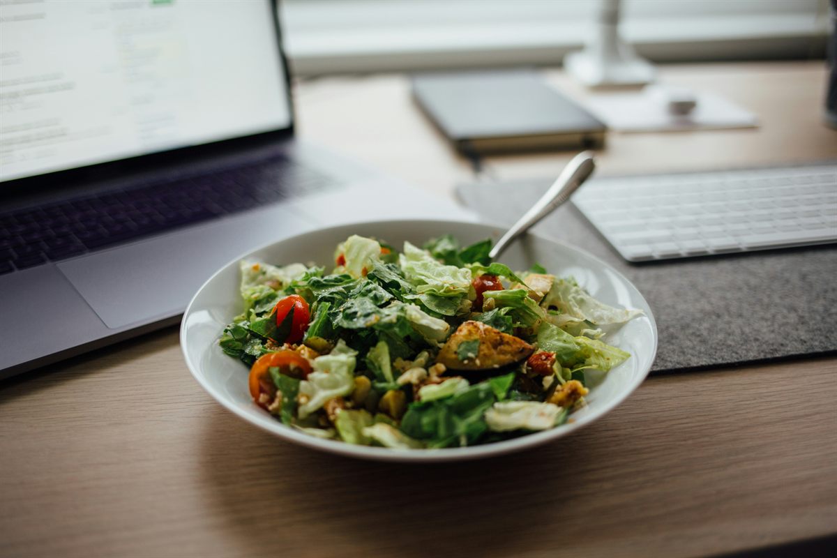 Escritorio de oficina con comida saludable y laptop — equilibrio entre trabajo y alimentación en San Luis Potosí